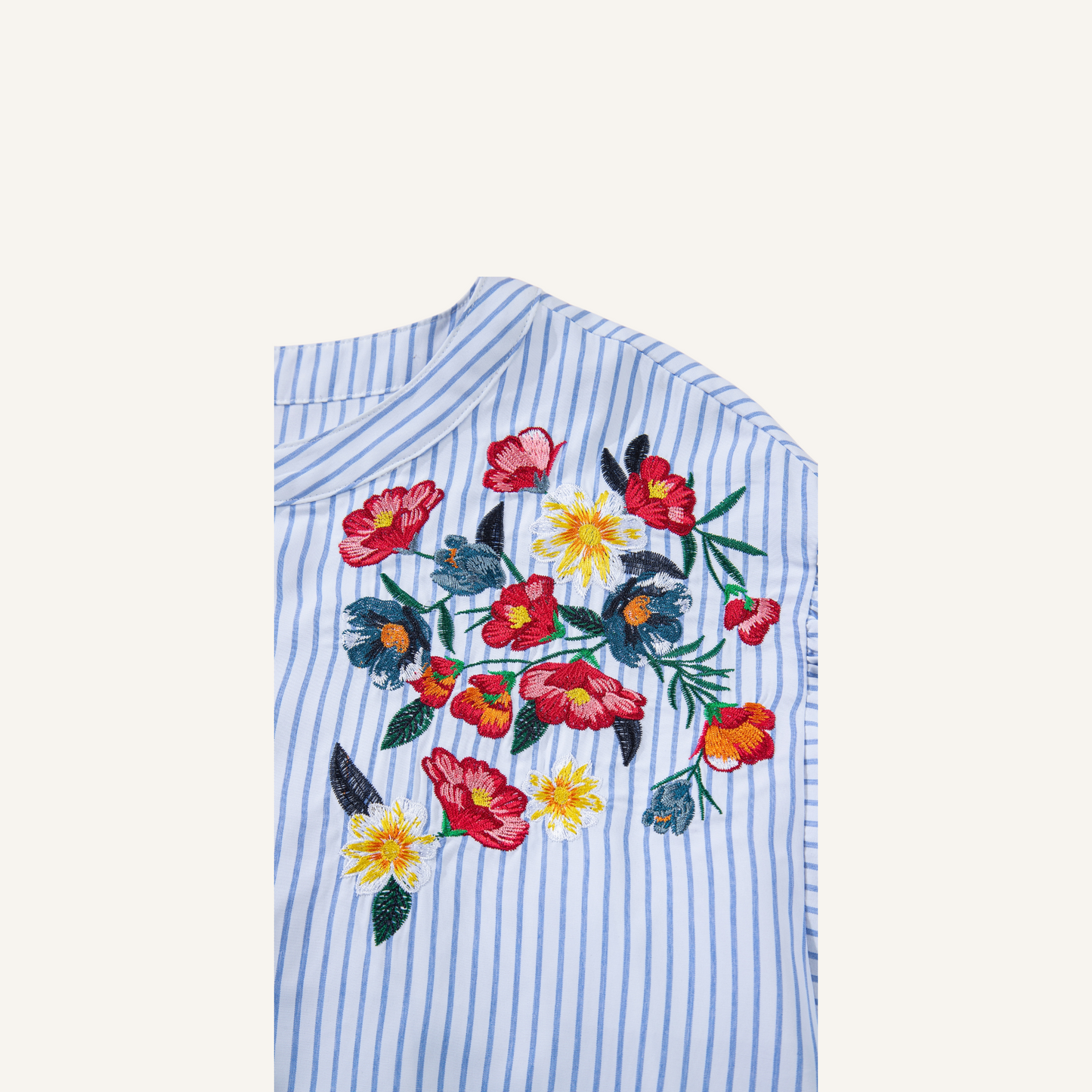 Close-up of intricate red and yellow floral embroidery on a blue pinstripe 100% polyester fabric.