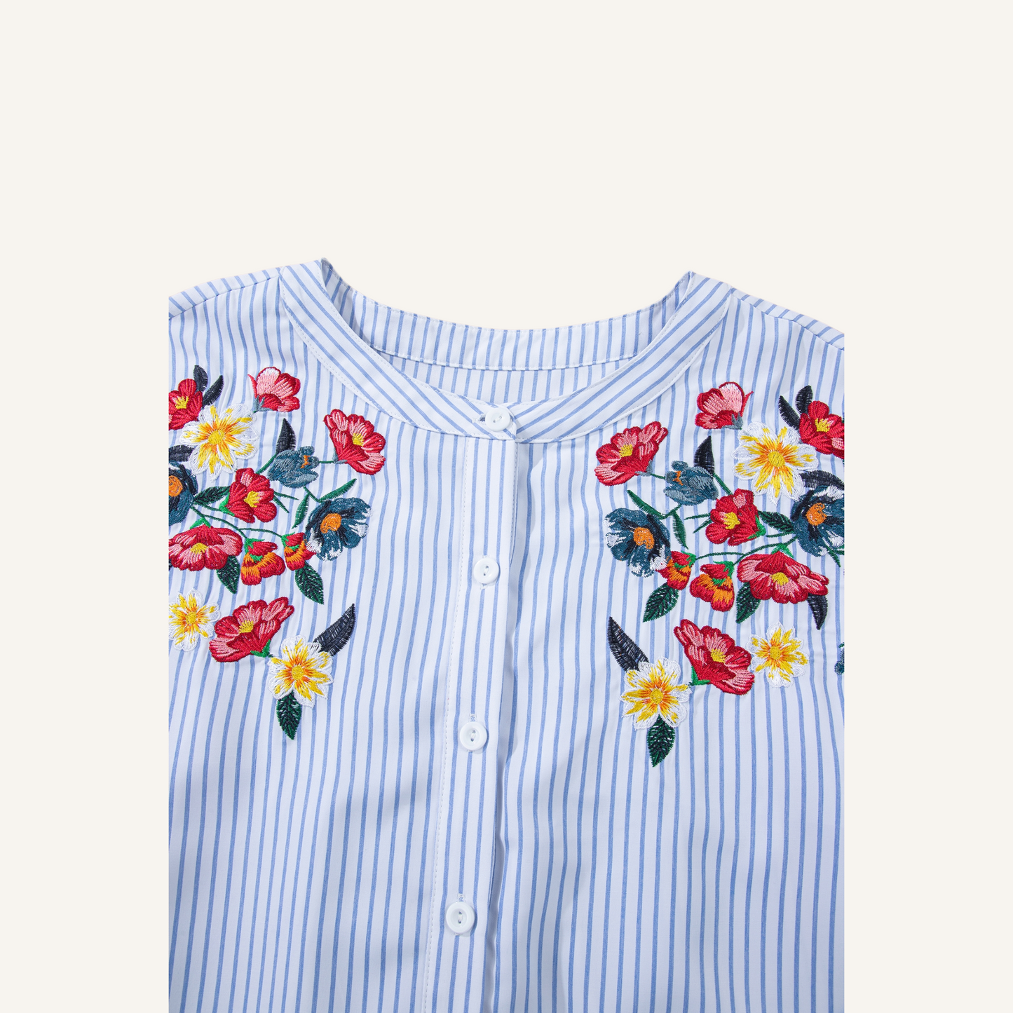 Close-up of intricate red and yellow floral embroidery on a blue pinstripe 100% polyester fabric.