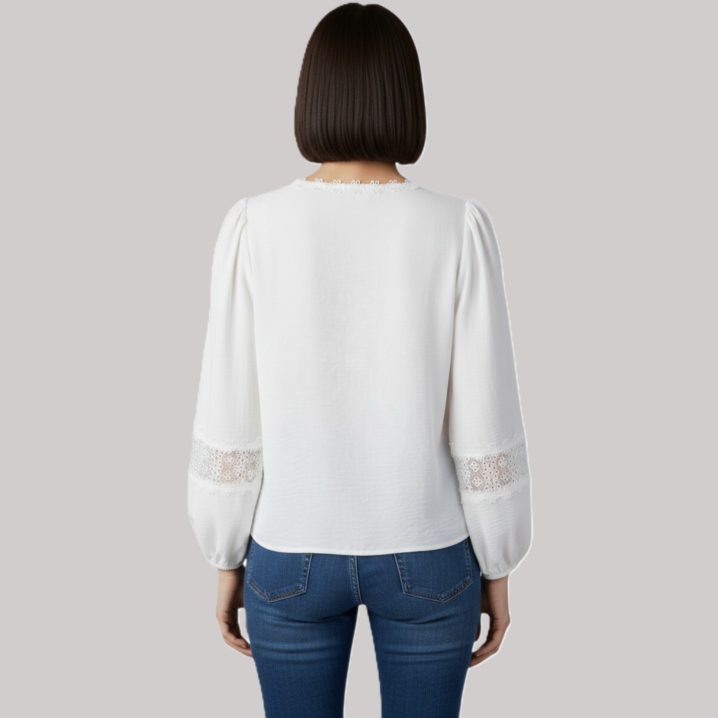 Rear view of an elegant white lace blouse showcasing a relaxed fit, gathered shoulders, and intricate floral lace inserts on the sleeves.