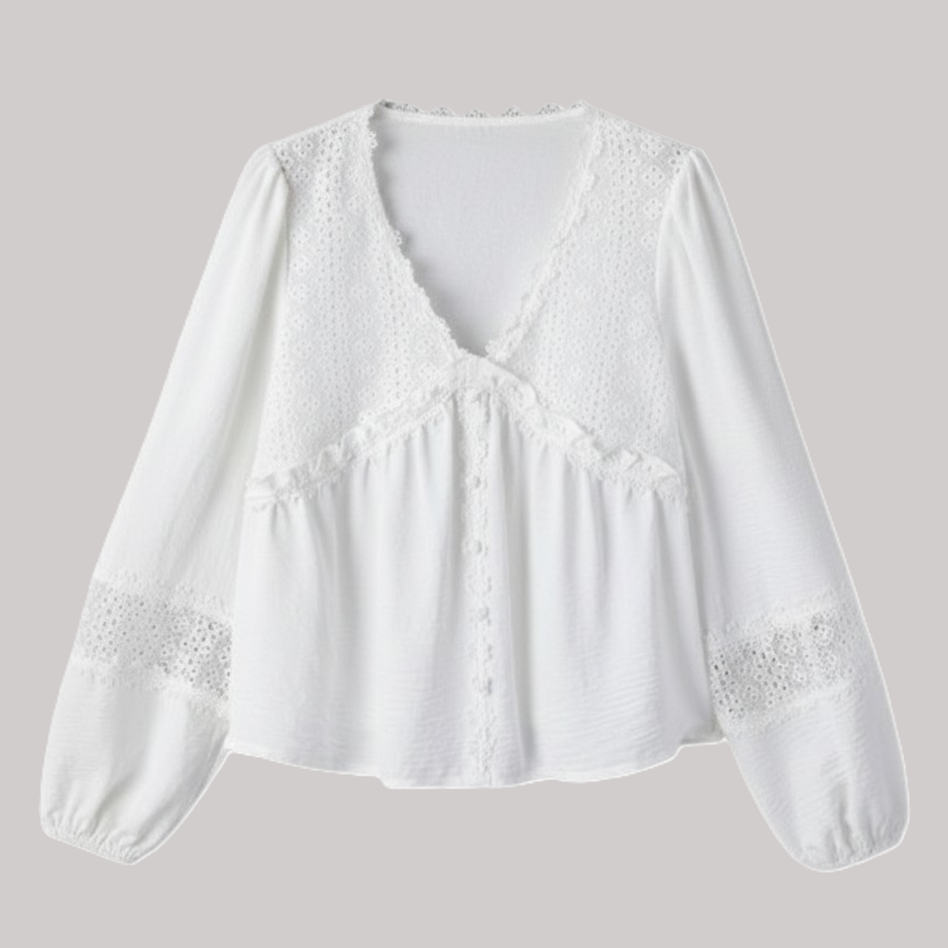A flat-lay studio shot of a white long-sleeve blouse featuring intricate floral guipure lace patchwork on the chest and sleeves, a frilled V-neckline, and a relaxed, breezy silhouette.
