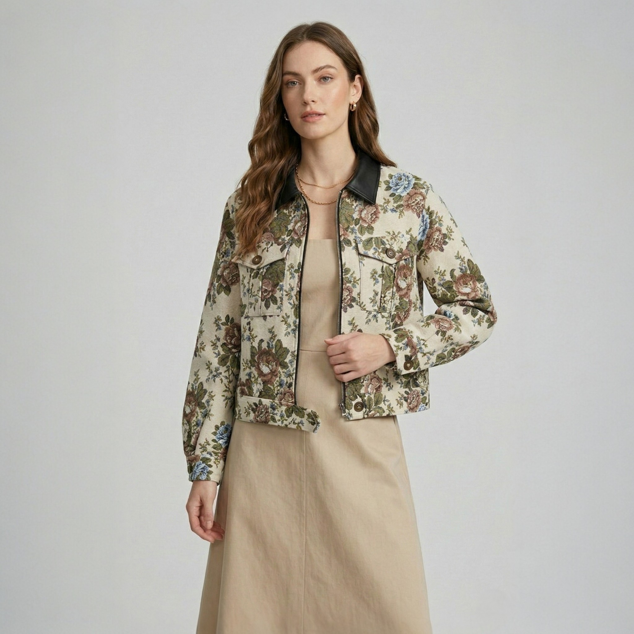 A model wearing a beige floral jacquard cropped jacket with a black collar, styled with a matching dress. 