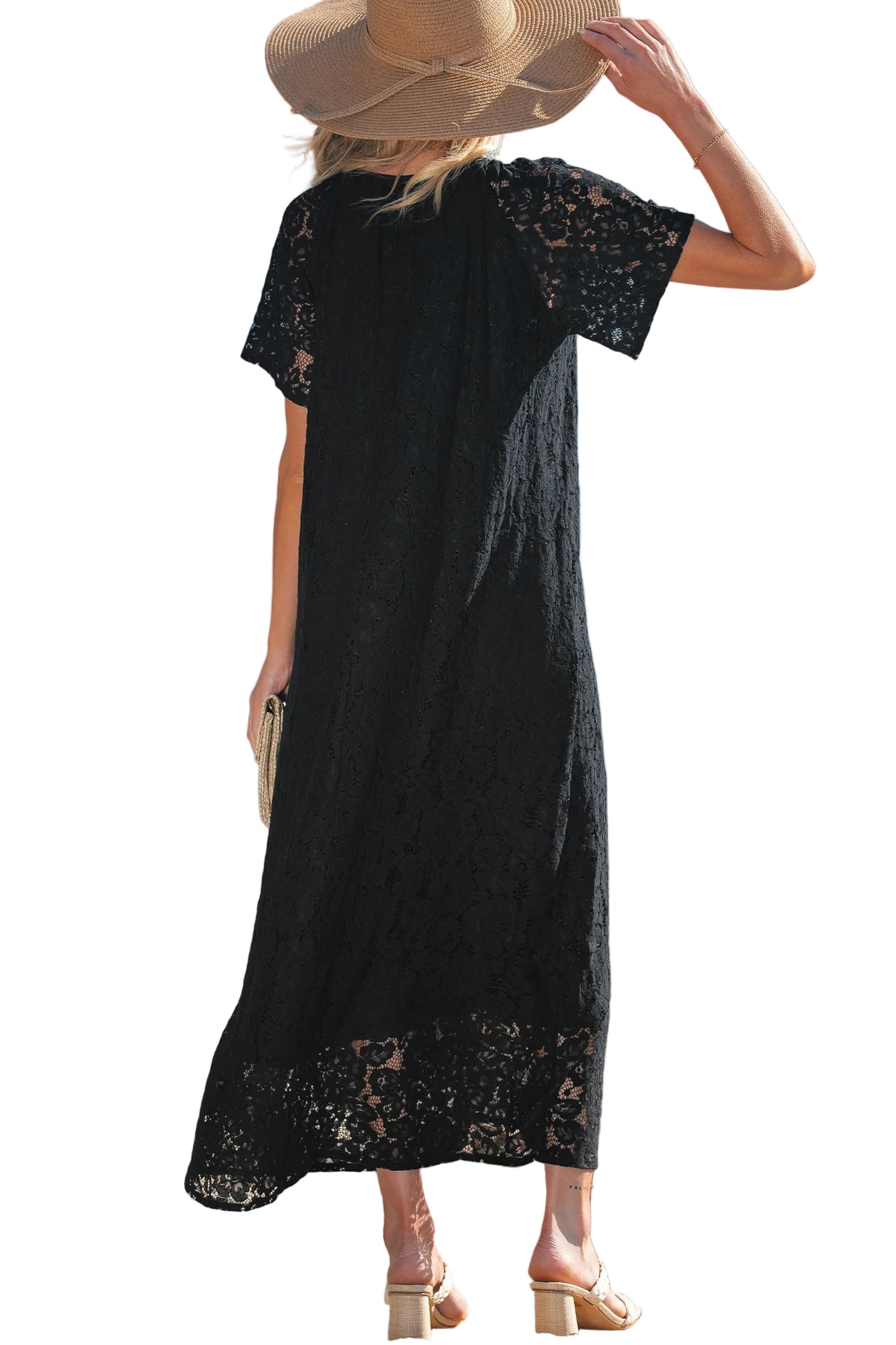 Woman wearing a black dress with lace details and a straw hat on a white background
