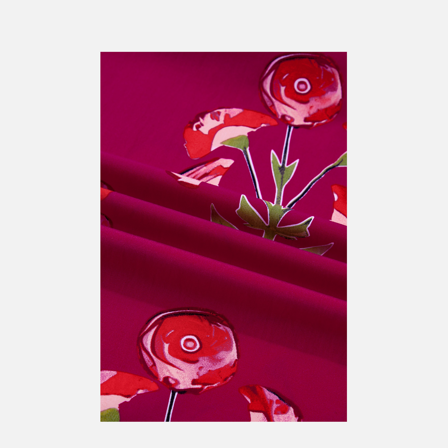 Close-up view of the fabric showing a vibrant fuchsia base with red and coral floral print pattern.