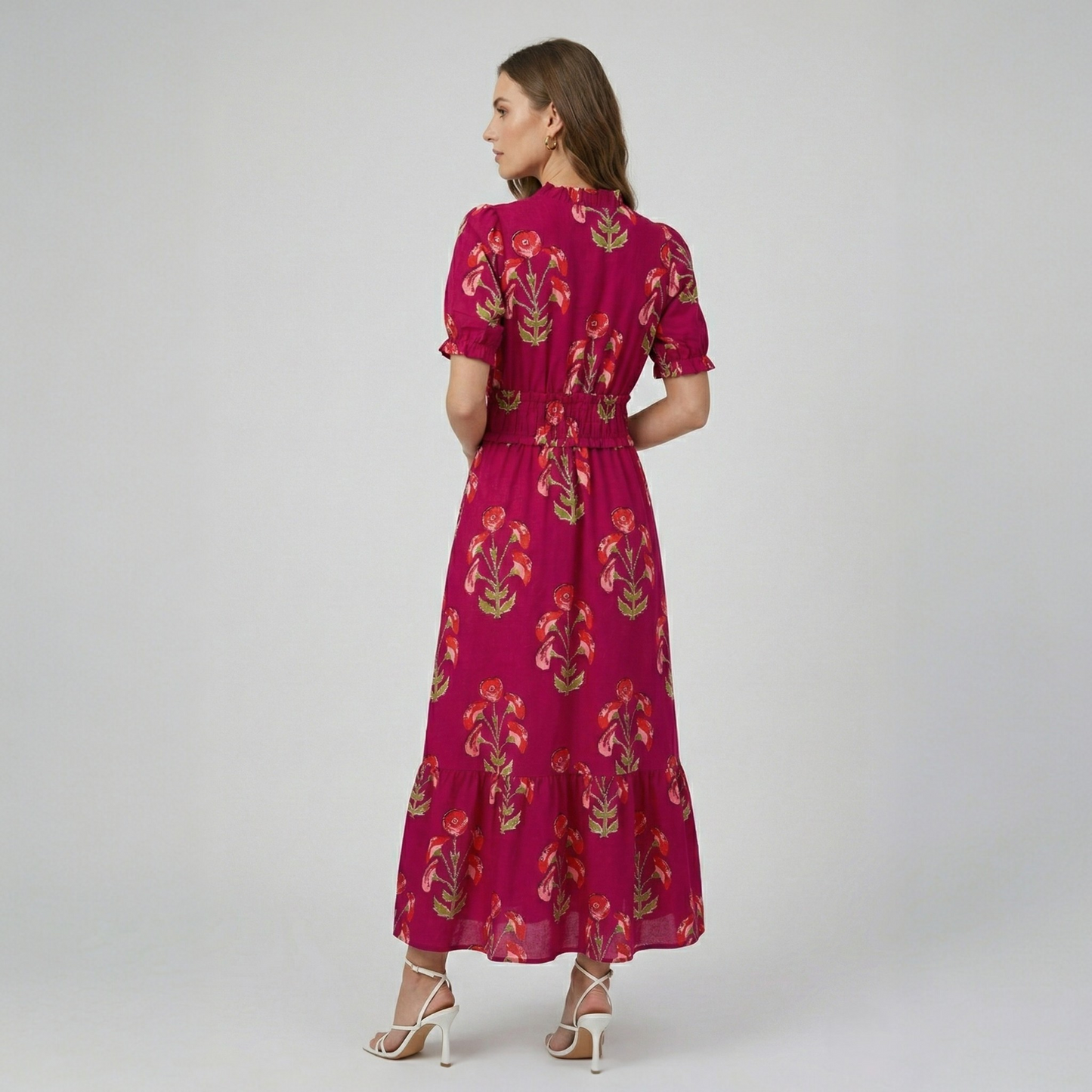 Model wearing a fuchsia floral print tiered maxi dress, back view highlighting the gathered waist and tiered silhouette.