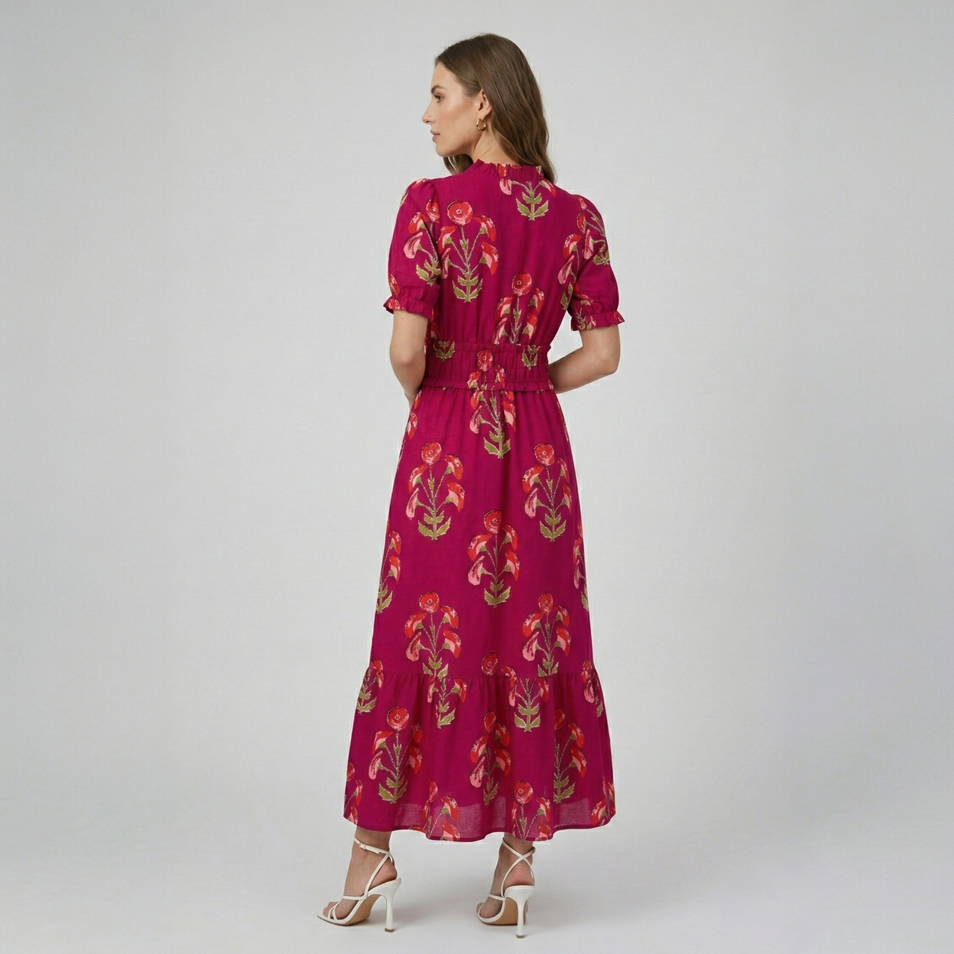 Model wearing a fuchsia floral print tiered maxi dress, back view highlighting the gathered waist and tiered silhouette.