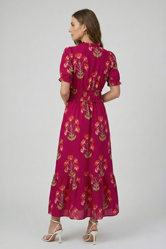 Model wearing a fuchsia floral print tiered maxi dress, back view highlighting the gathered waist and tiered silhouette.