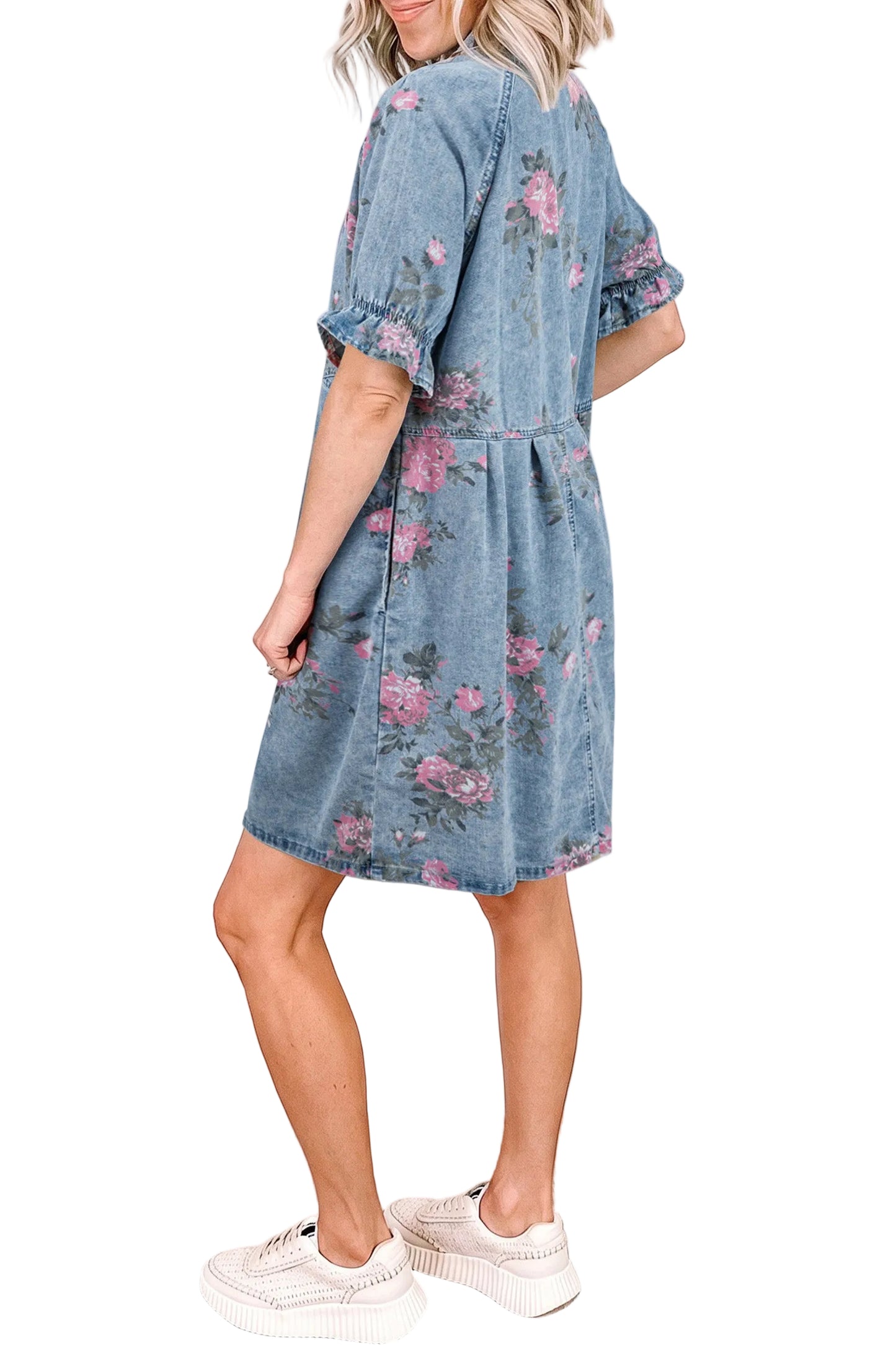 Woman wearing a denim dress with floral patterns against a white  background