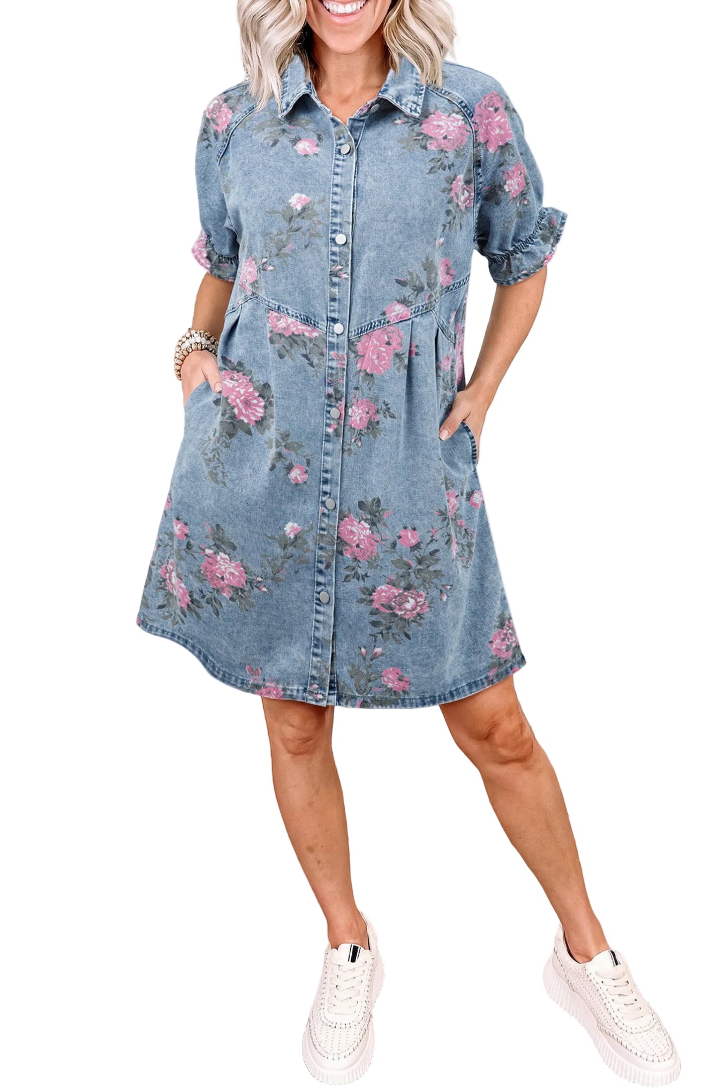 Woman wearing a floral denim dress standing against a white  background