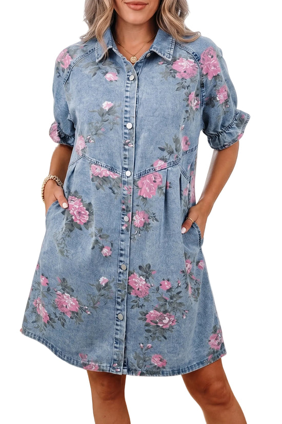 Front view of a model wearing a washed blue denim mini shirt dress featuring a pink rose print, button front, and side pockets.