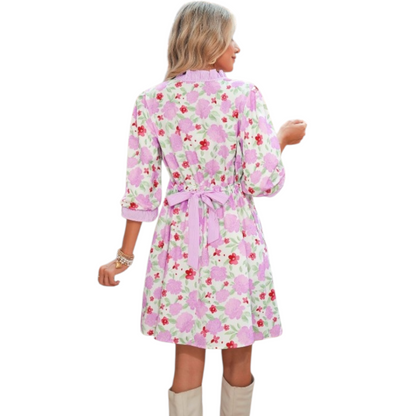 Floral print mini dress with a ruffle neck and pockets. Back view.