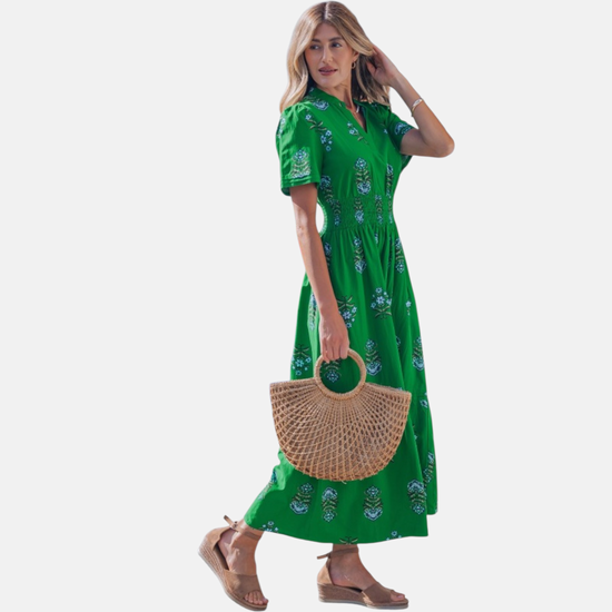 Side profile of the floral print maxi dress, illustrating the soft drape of the fabric and the elegant movement of the tiered skirt.