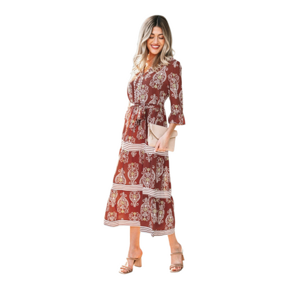 Woman wearing a rust-brown paisley floral maxi dress with a matching waist tie belt and flutter sleeves.