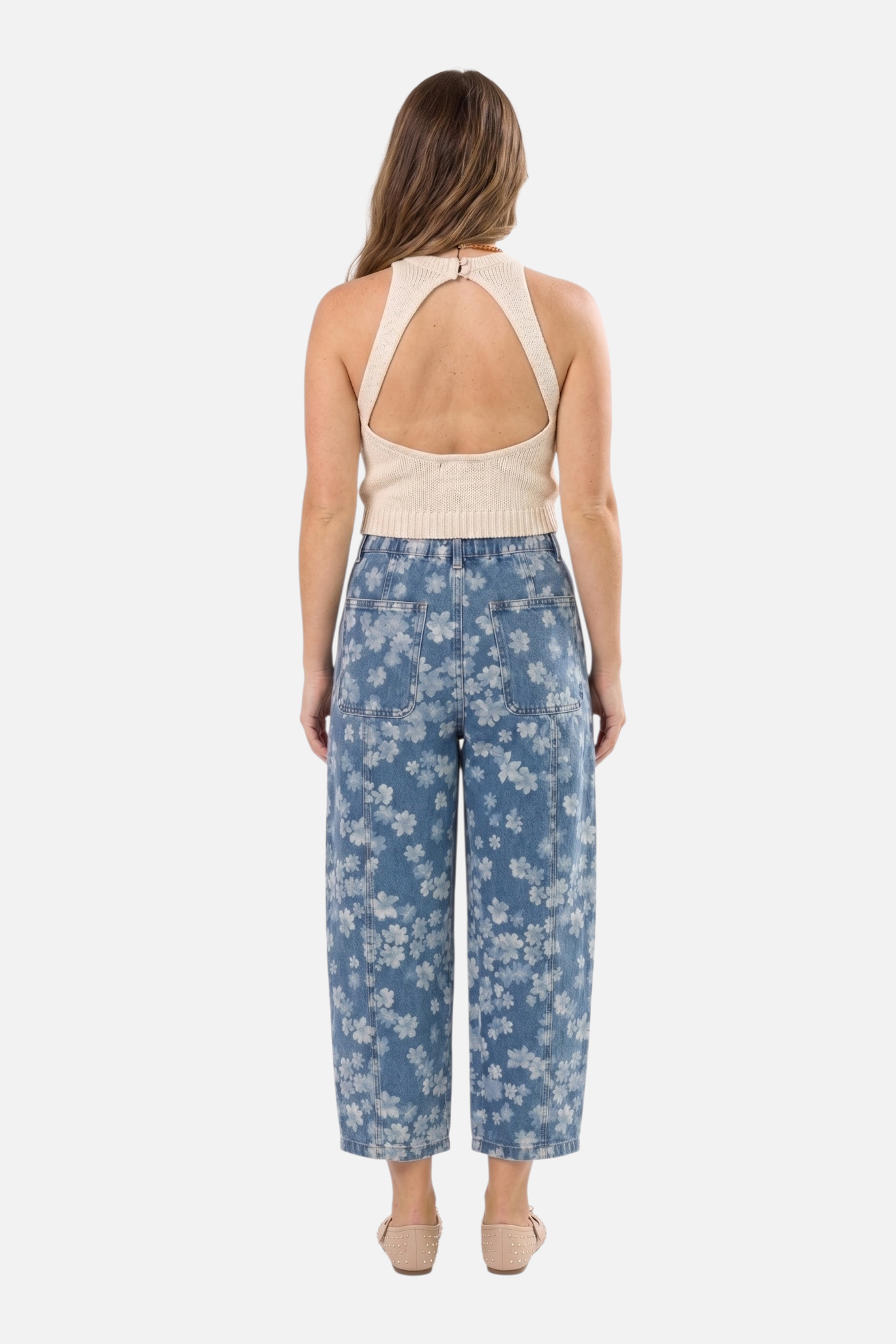 Rear view of the floral print jeans highlighting the high-waisted fit, practical back pockets, and the consistent all-over white floral botanical pattern.