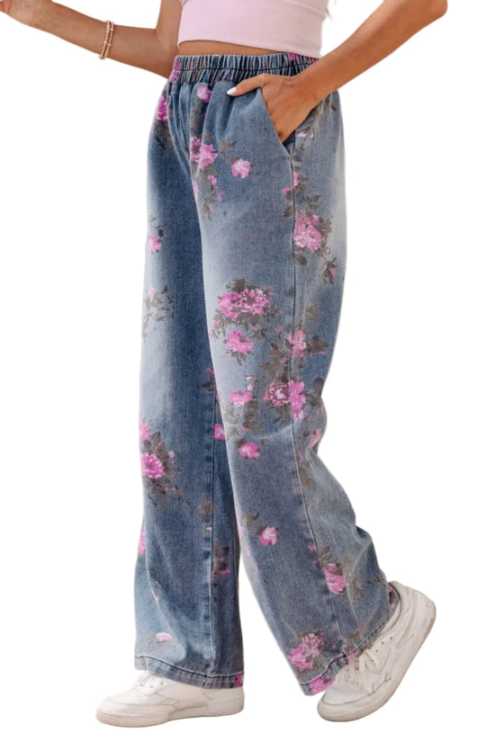Person wearing floral denim pants with a plain background