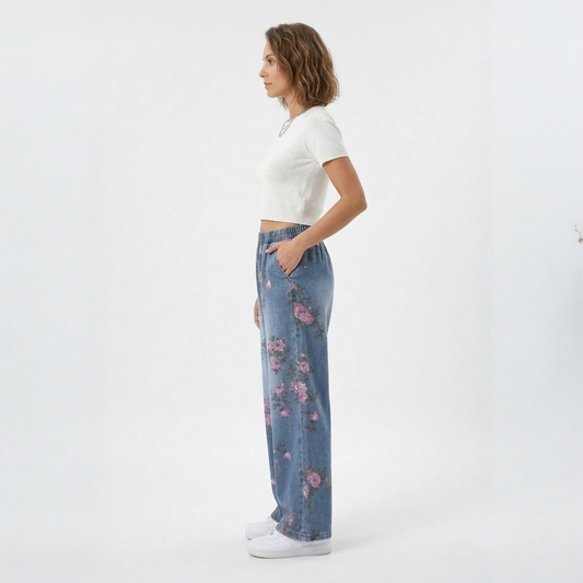 Side profile of the floral print denim trousers, highlighting the spacious wide-leg silhouette and functional side pockets.
