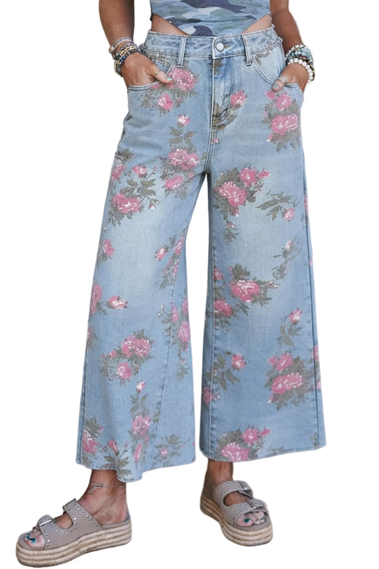 Person wearing light blue jeans with pink floral patterns against a white background