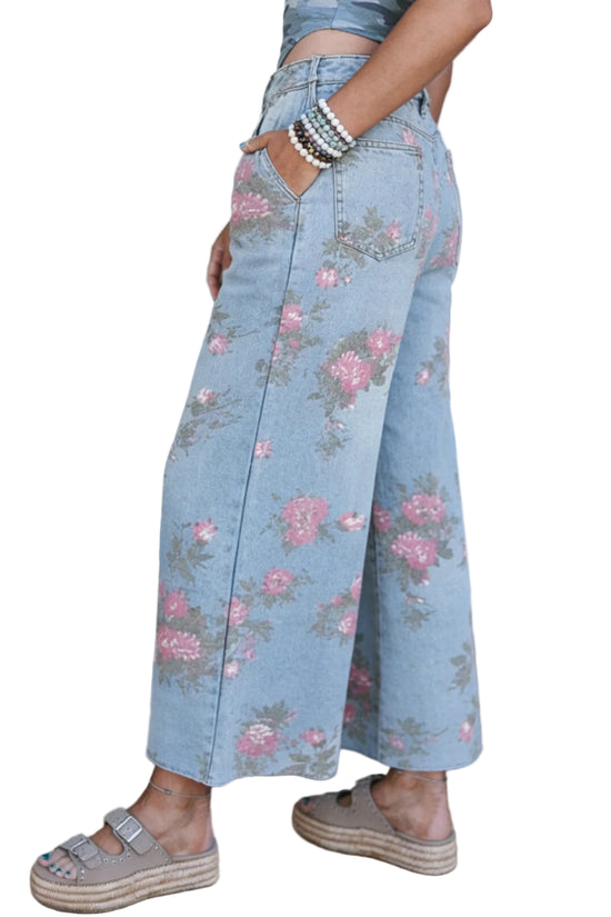 Person wearing light blue floral wide-leg pants with a white background