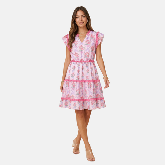 Full-length front view of a model wearing a V-neck floral mini dress with ruffled flutter sleeves against a white background.