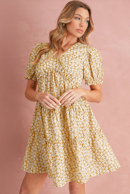 Woman wearing a yellow floral dress against a pink background