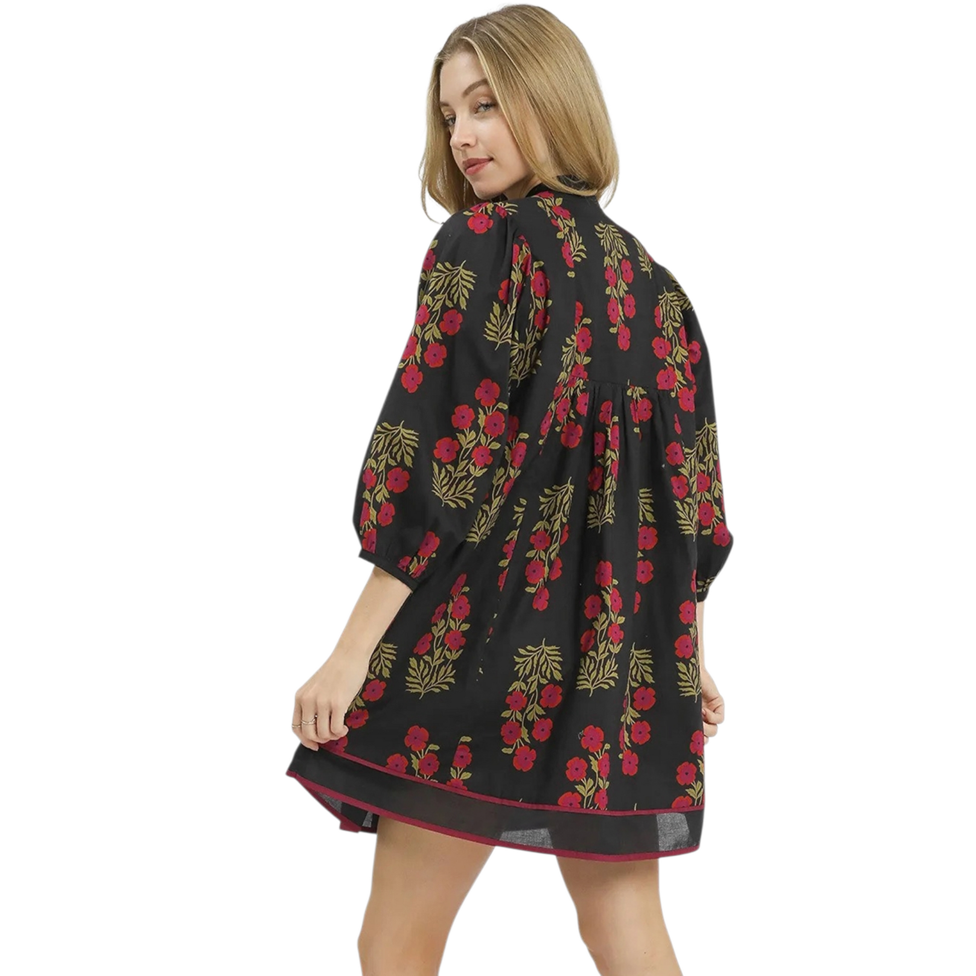 Rear view of a black floral mini dress showing a relaxed A-line silhouette, bracelet-length sleeves, and a gathered back detail.