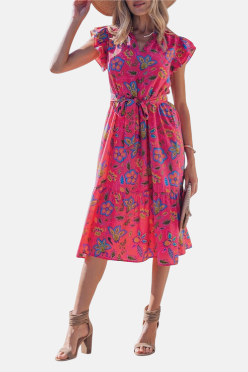 Full-length front view of the belted floral midi dress, showcasing the high-impact pink and blue botanical print and the airy tiered silhouette.