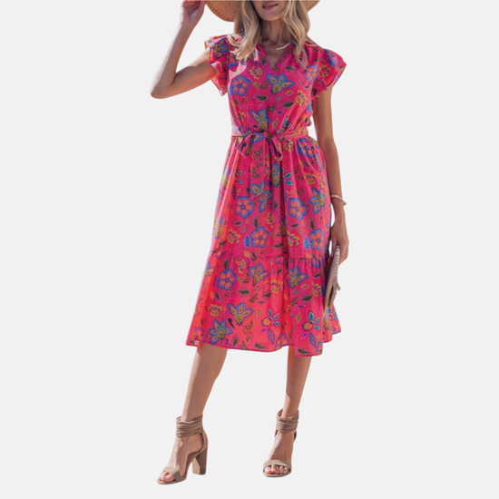 Full-length front view of the belted floral midi dress, showcasing the high-impact pink and blue botanical print and the airy tiered silhouette.