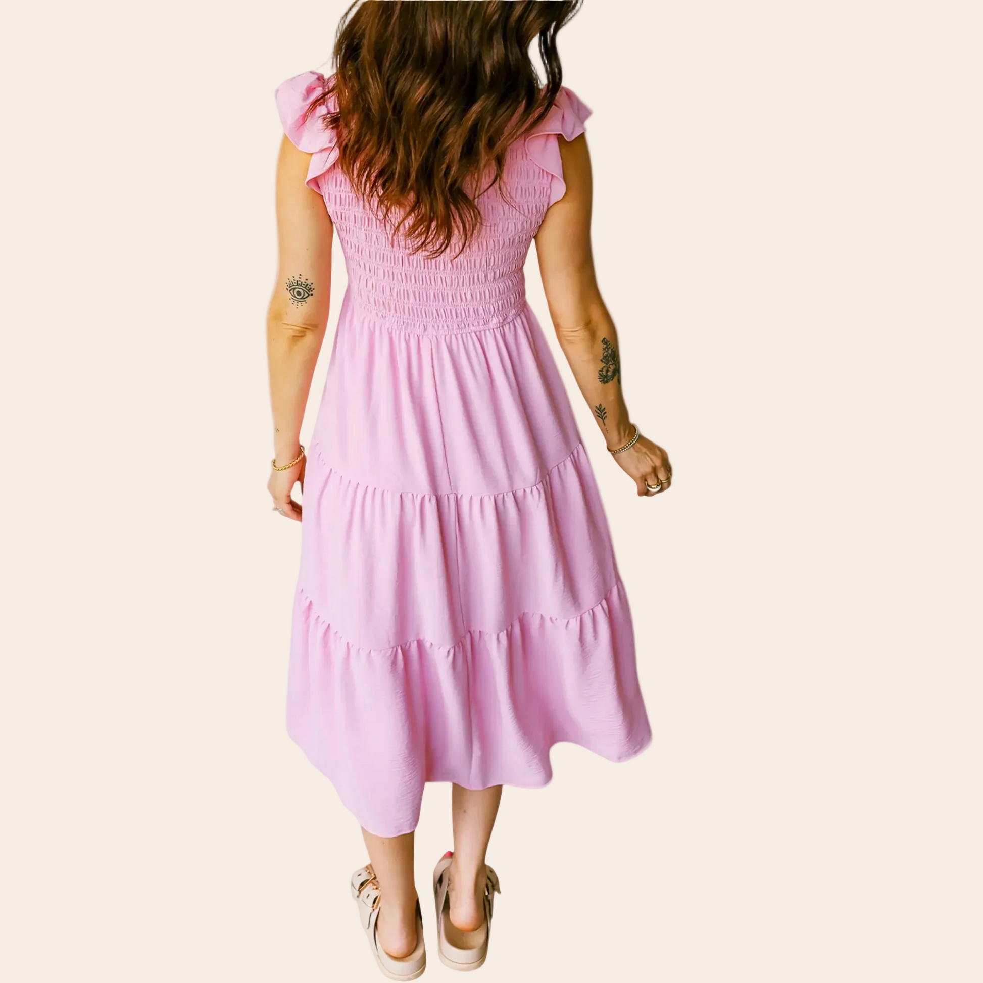 Woman wearing a pink dress against a pink background