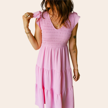 Woman wearing a pink dress against a plain background