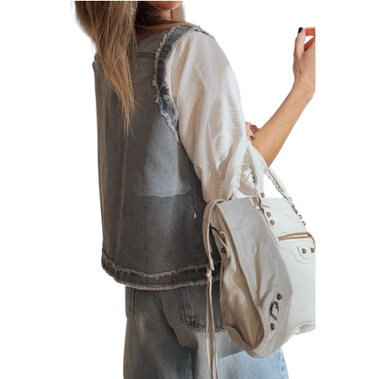 Person holding a beige handbag with a white background