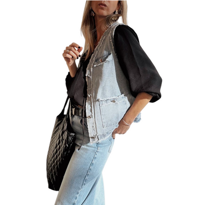 Person wearing a black shirt, denim jacket, and light blue jeans with a black handbag.