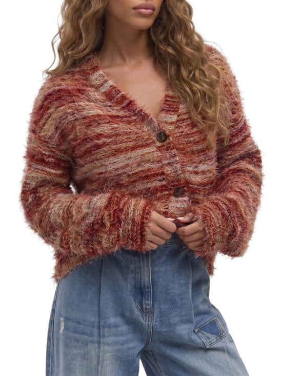 A woman wearing a fuzzy, textured cardigan sweater with horizontal stripes in rust red, terracotta, and beige, paired with high-waisted blue jeans against a plain white background.
