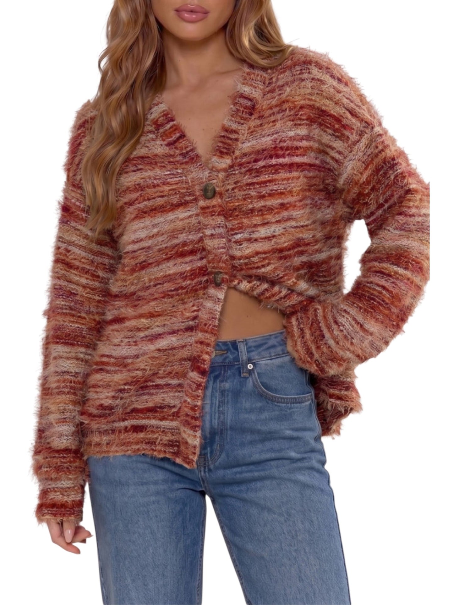 A woman wearing a fuzzy, long-sleeve cardigan with horizontal marled stripes in rust red, terracotta, and beige tones, paired with blue jeans against a plain white background.