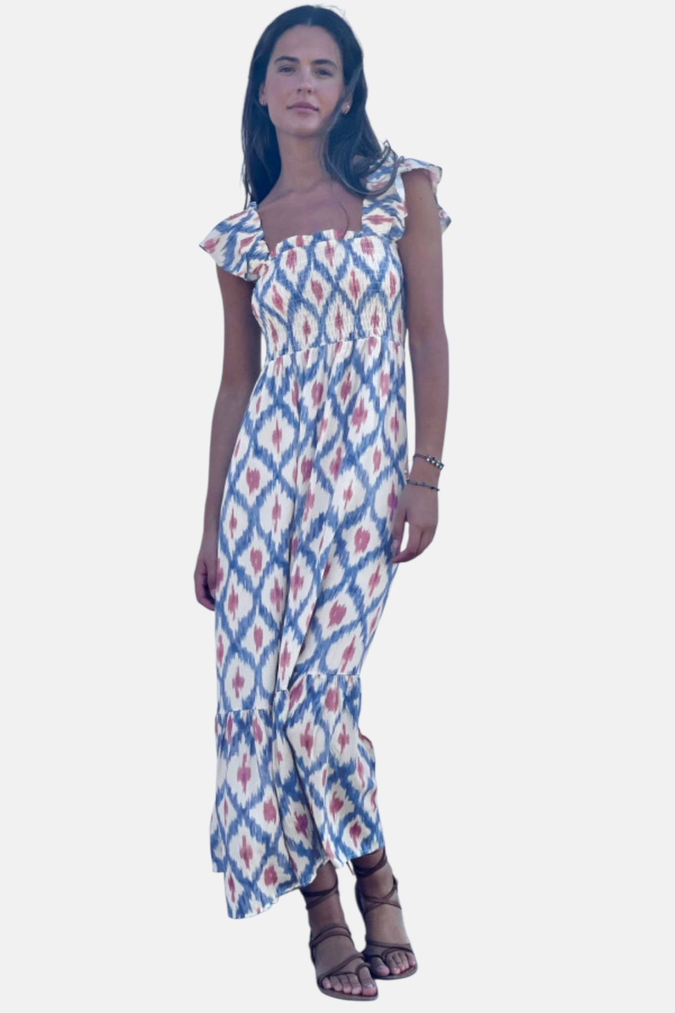 Full-length studio view of a model in a geometric print maxi dress featuring a smocked high-waist bodice and tiered ruffle hem.