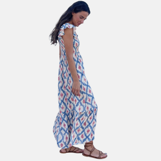 Side profile of the flowy maxi dress, emphasizing the flattering empire waist and the graceful drape of the ruffled skirt.