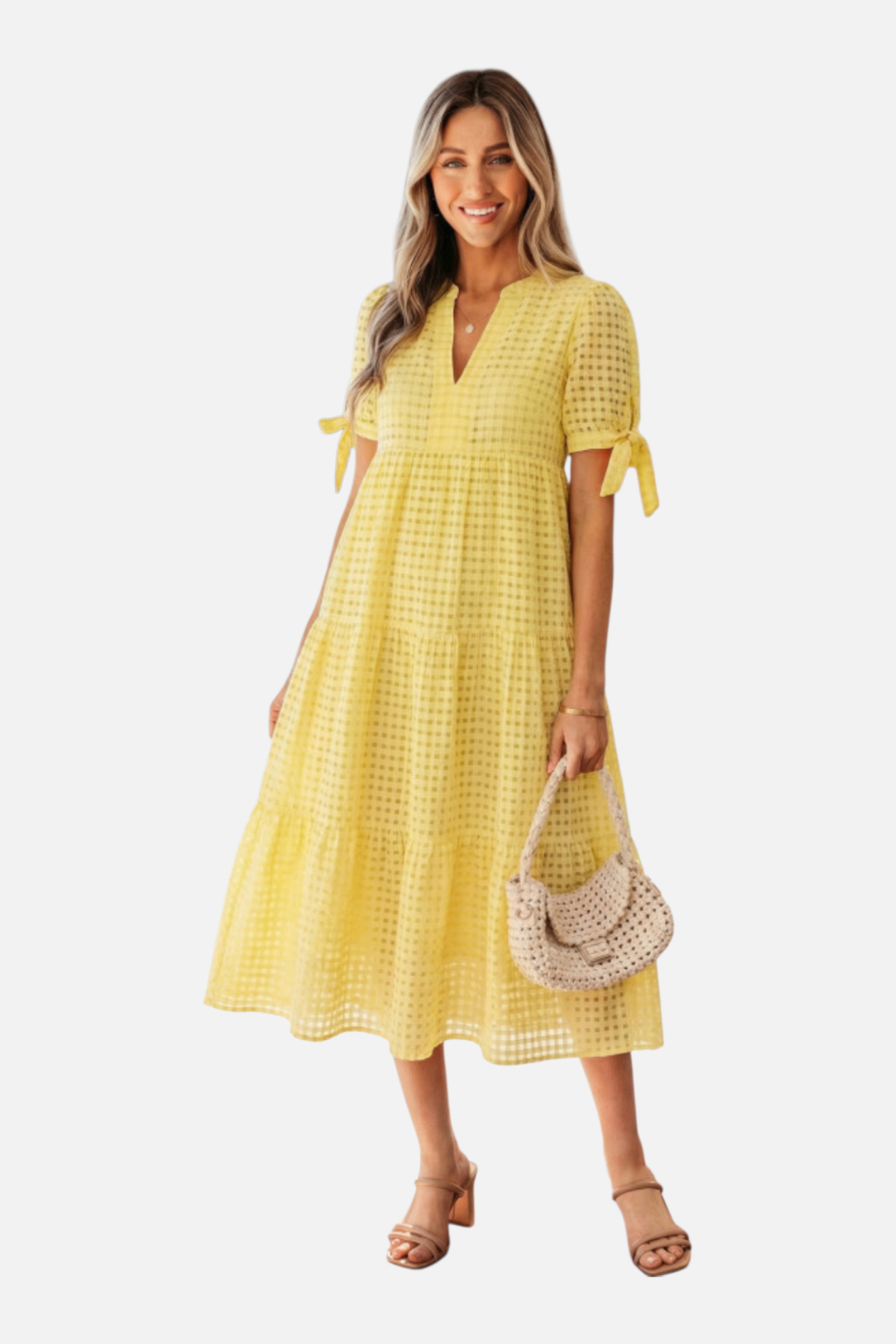 Woman wearing a yellow checkered dress holding a straw bag on a white background