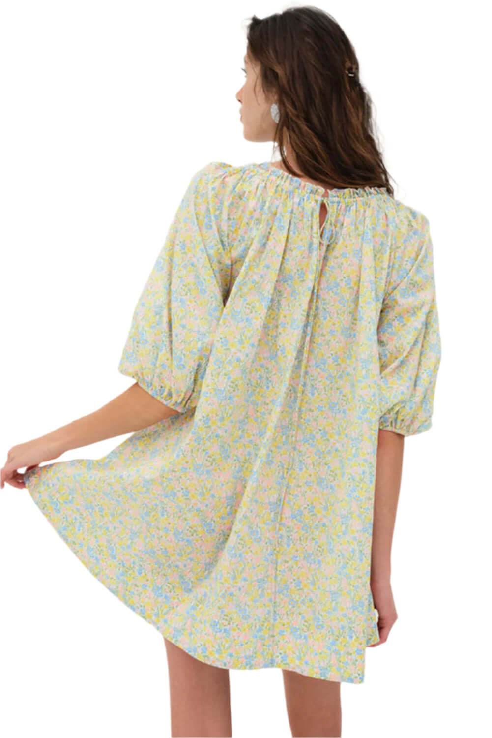 Back view of a green floral summer mini dress featuring puff sleeves and a flowing hem.
