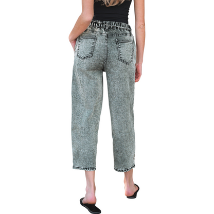 Model wearing grey acid wash barrel fit jeans with a drawstring waist and front panel detailing. Rear view.