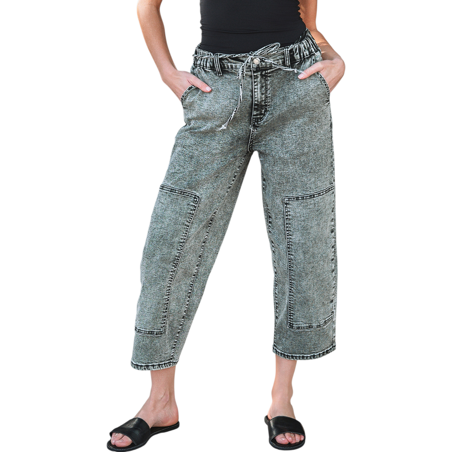 Model wearing grey acid wash barrel fit jeans with a drawstring waist and front panel detailing. 
