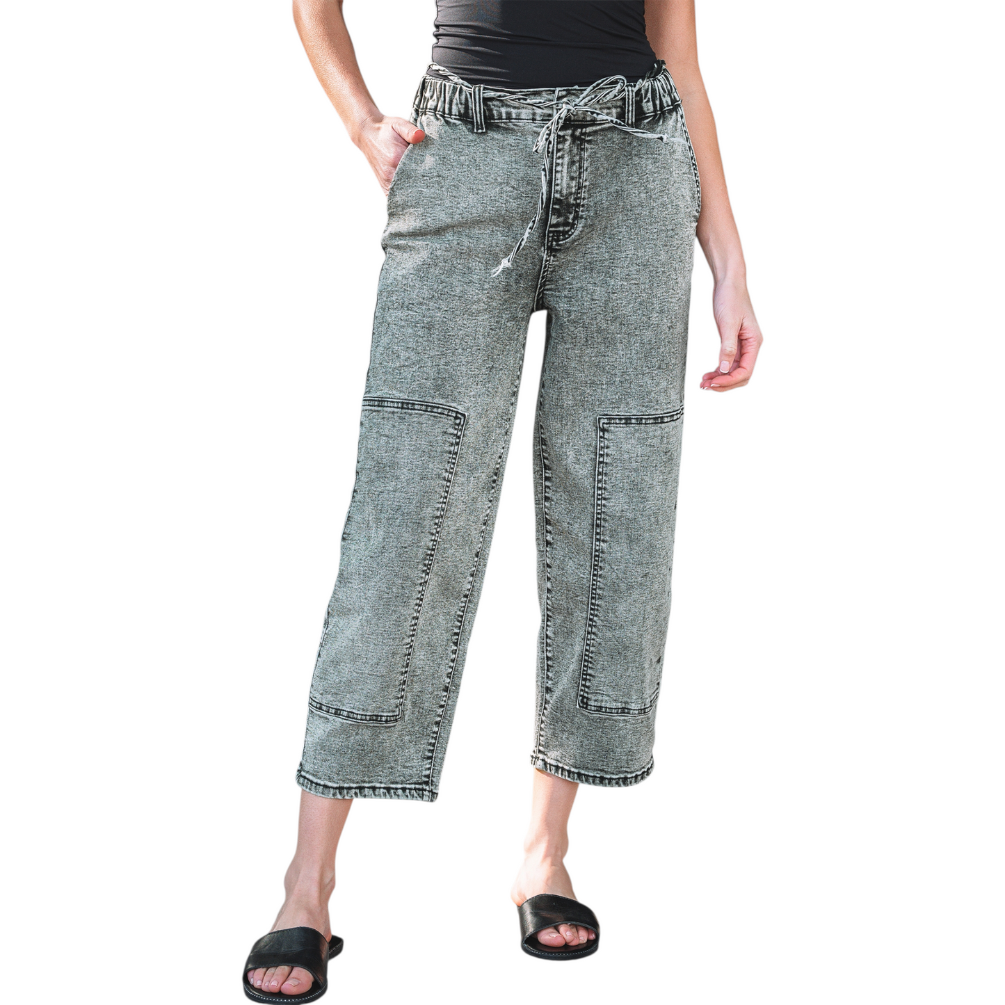 Model wearing grey acid wash barrel fit jeans with a drawstring waist and front panel detailing.