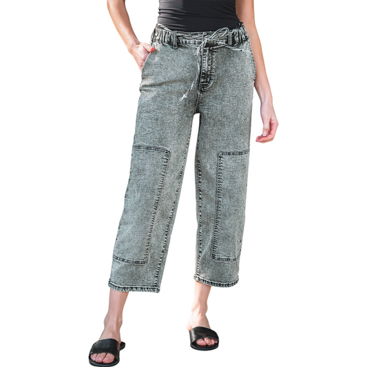 Model wearing grey acid wash barrel fit jeans with a drawstring waist and front panel detailing.