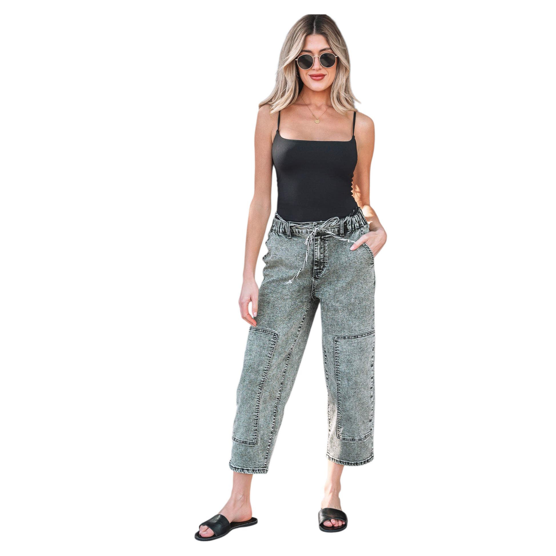 Model wearing grey acid wash barrel fit jeans with a drawstring waist and front panel detailing. 