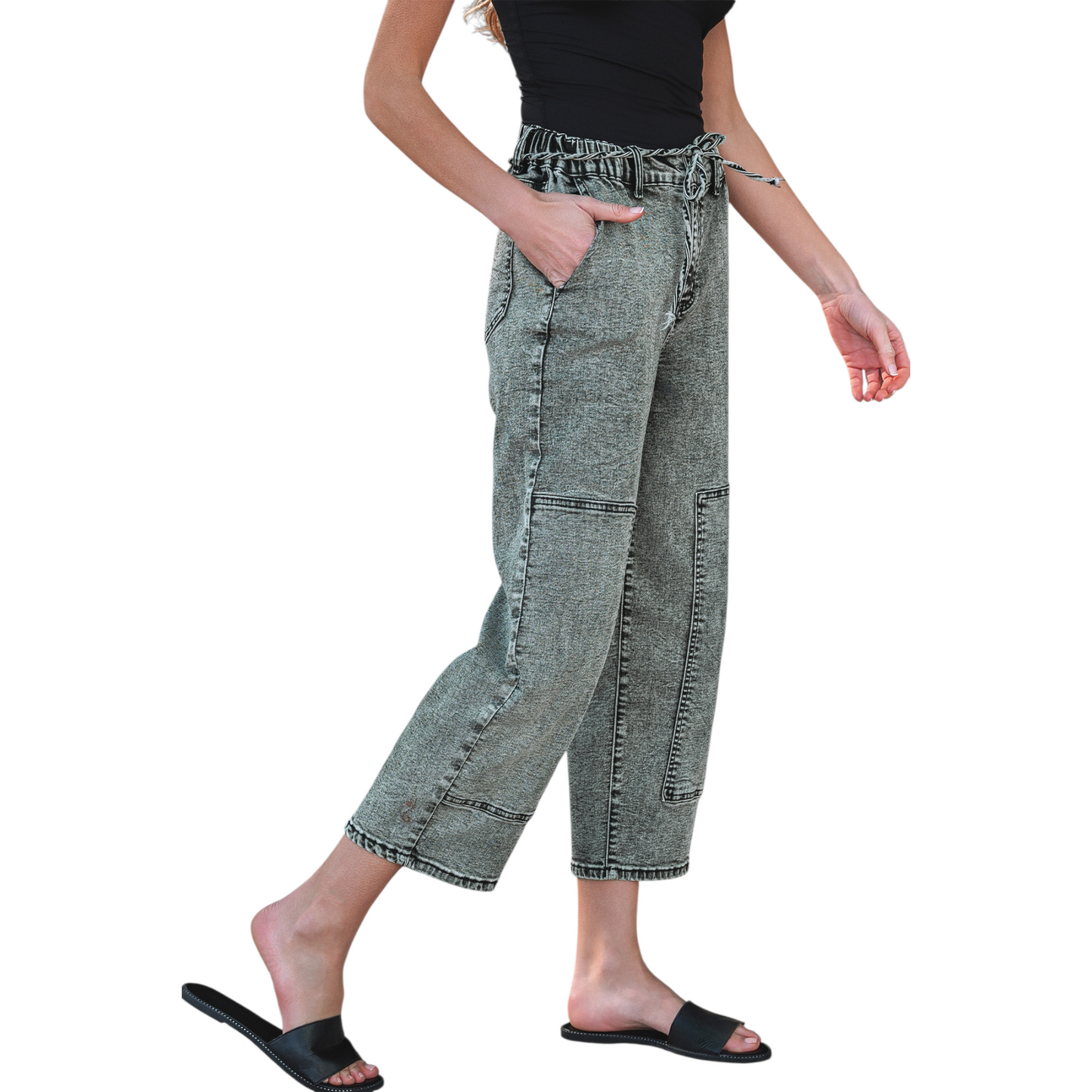 Model wearing grey acid wash barrel fit jeans with a drawstring waist and front panel detailing. Side view.