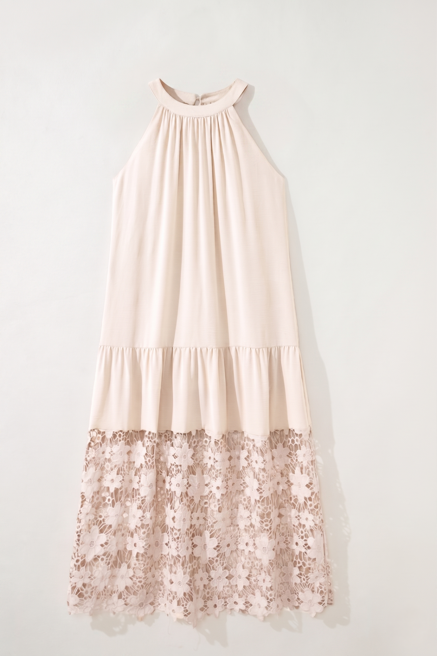 Blush pink dress with floral lace hem on a white background
