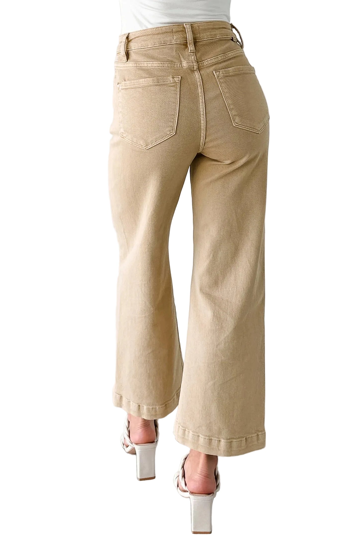 Beige jeans worn by a person on a marble floor with a white background