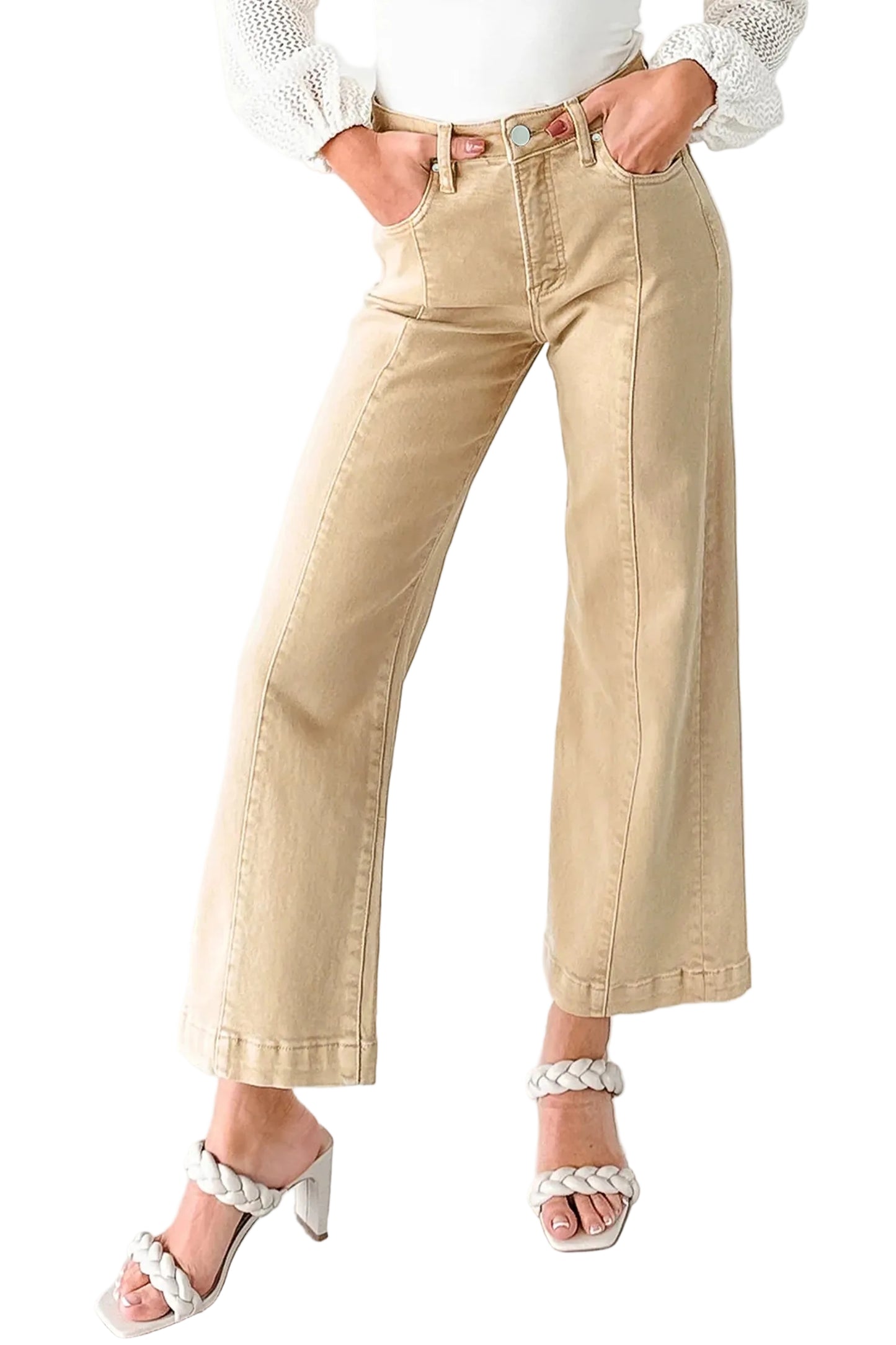 Person wearing beige wide-leg pants and white sandals on a white floor.