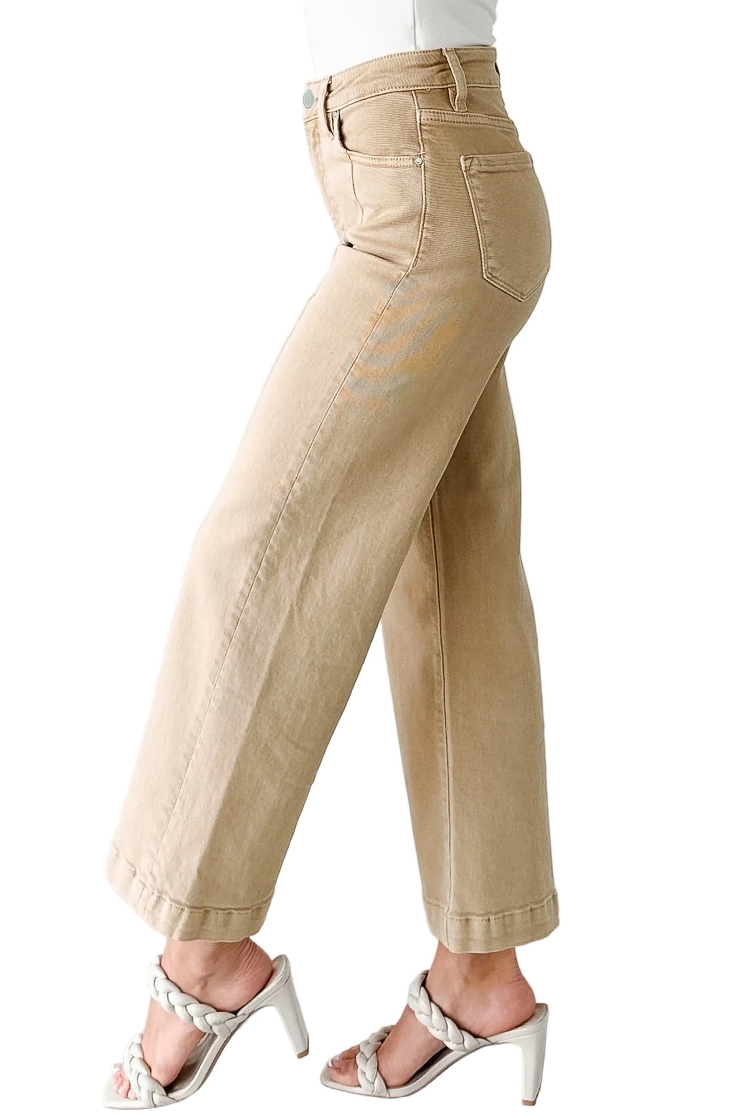 Beige wide-leg cropped jeans worn by a person on a white background