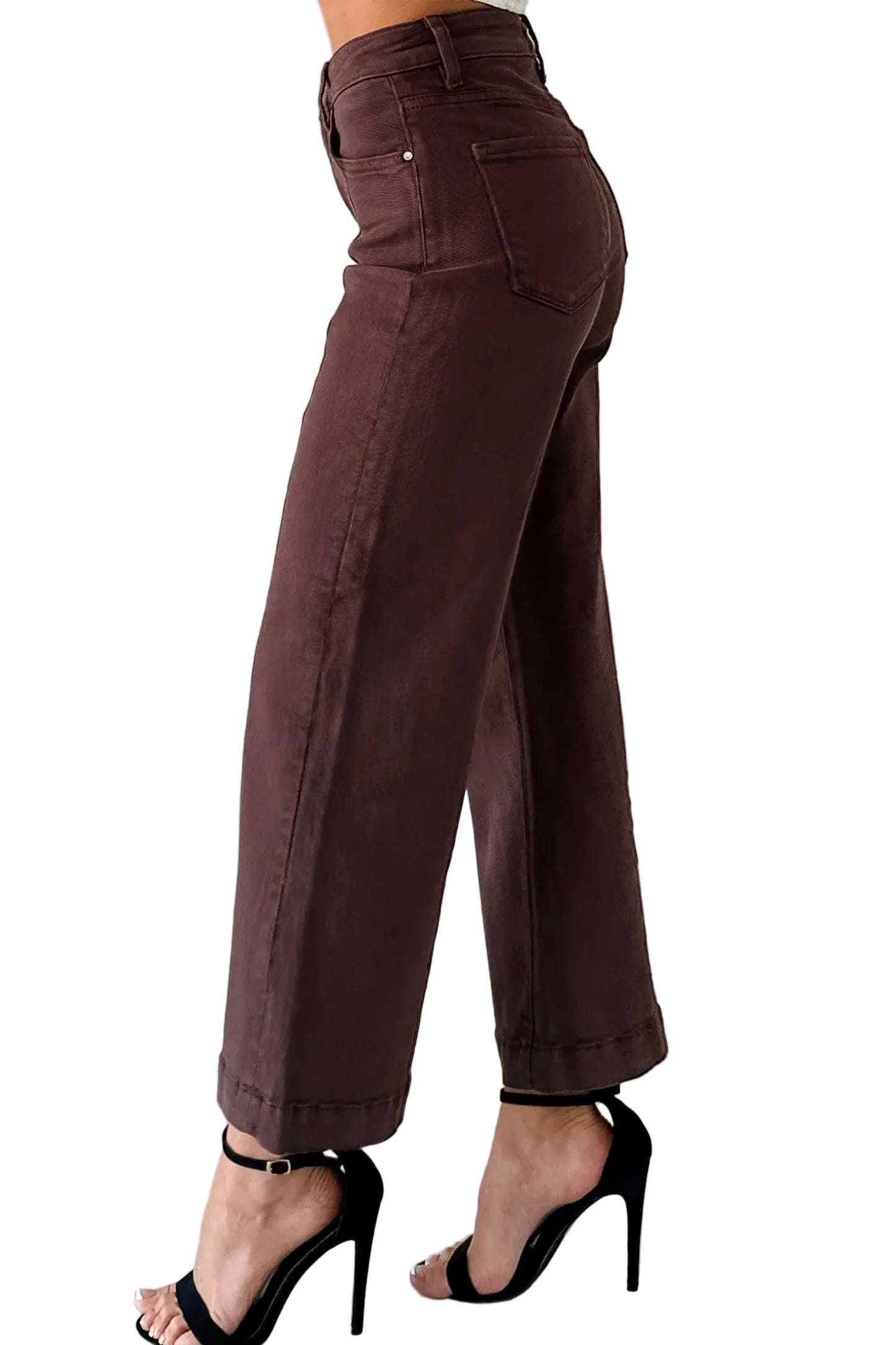 Brown pants worn by a person on a light gray floor with a white  background