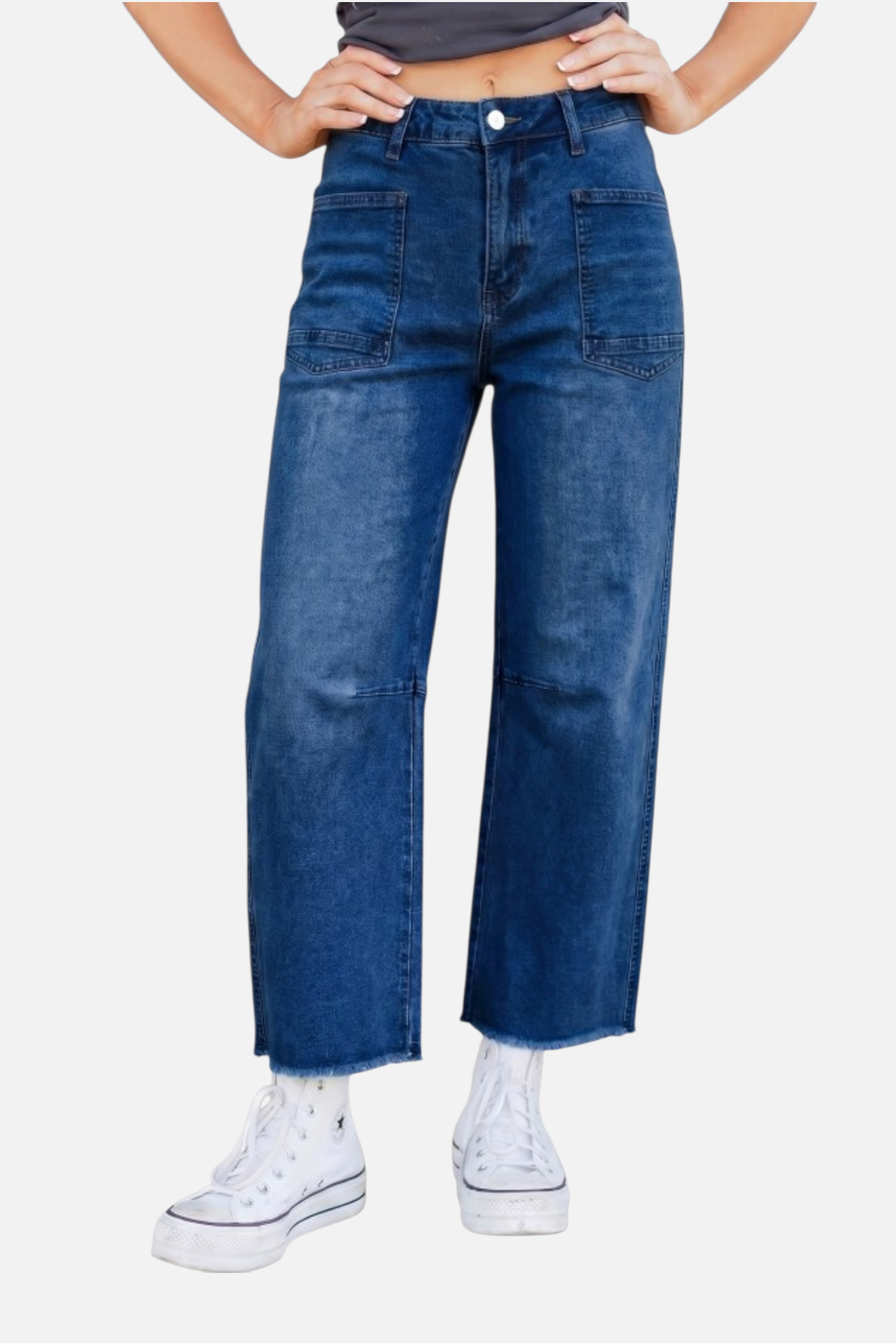 Person wearing blue jeans and white sneakers on a plain background