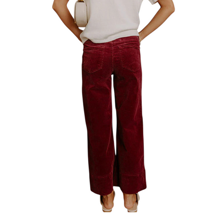 Back view of burgundy wide-leg corduroy trousers showing the high-waisted fit and functional rear pockets.