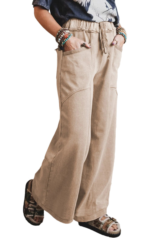 Person wearing beige wide-leg pants with a neutral background